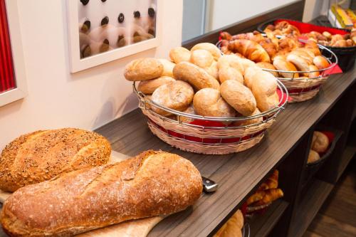 a table topped with lots of different types of bread at Hotel Saint Sauveur by WP Hotels in Blankenberge