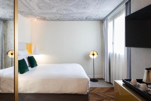 Кровать или кровати в номере Le Louis Hotel Versailles Château - MGallery Collection