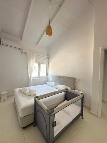 a bedroom with a bed in a white room at Villa Naturaleza in Loutsa