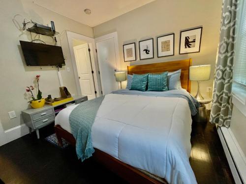 a bedroom with a large bed and a television at Beautiful 3BR 3BA Duplex parking Best Location Boston in Boston
