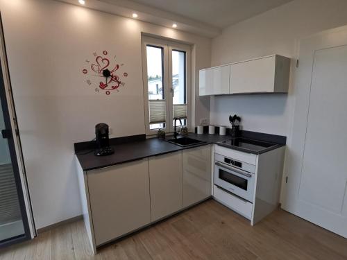 a kitchen with white cabinets and a counter top at Villa Strandläufer im Villen-Ensemble in Baabe