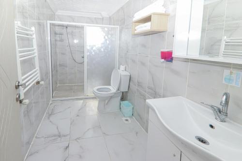 un bagno bianco con un water e un lavandino di PARADİSE pansiyon otel a Nilüfer