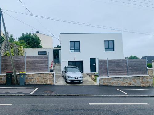 a car parked in a parking lot in front of a house at Appartements proches de la mer in Le Relecq-Kerhuon