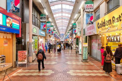 a group of people walking through a shopping mall at New Cozy APT Located on the Japanese Local shopping street in Tokyo