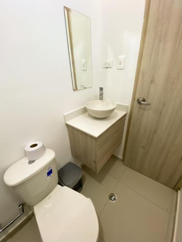 a bathroom with a toilet and a sink and a mirror at Hotel Boutique Betania in Valledupar