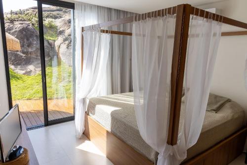 ein Schlafzimmer mit einem Bett und einem großen Fenster in der Unterkunft Casa LUXO c/ vista panorâmica em Vila Velha-SH095D in Convento da Penha