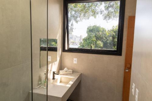 ein Badezimmer mit Waschbecken und Fenster in der Unterkunft Casa LUXO c/ vista panorâmica em Vila Velha-SH095D in Convento da Penha