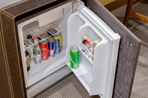 an open refrigerator filled with drinks and sodas at La Bohème Hotel in Tirana