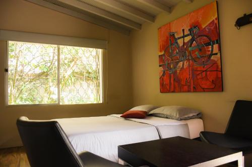Dos camas en una habitación con un cuadro en la pared. en Alojamiento que permite mascota en Medellín A103 By Roots Rentals, en Medellín