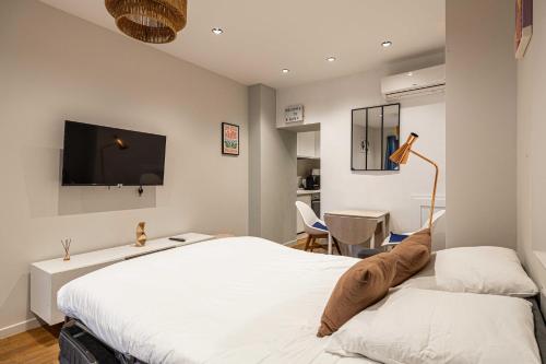 une chambre avec un lit et une télévision à écran plat dans l'établissement Cozy renovated studio - Cannes Meynadier, à Cannes