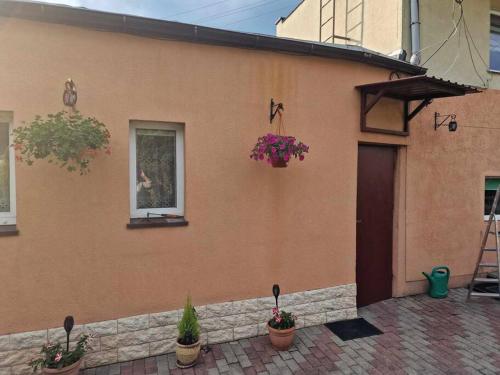 a house with potted plants on the side of it at Pod Brzózką in Gdynia