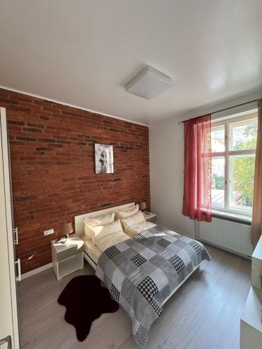 Un dormitorio con una cama y una pared de ladrillo. en Arbes 10 - At the yellow Duck, en Praga