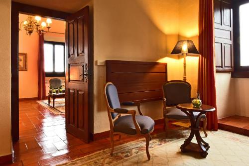 a living room with two chairs and a table at Pousada Castelo de Palmela in Palmela