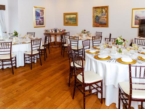 a room with tables and chairs with white tablecloths at Mirbeau Inn & Spa - Skaneateles in Skaneateles
