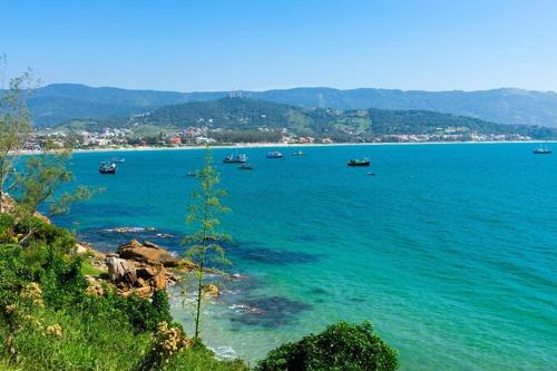 a large body of water with boats in it at Casa na Praia centro de Garopaba in Garopaba