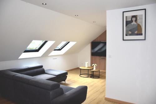 a living room with a couch and a skylight at Hôtel Bagatelle Paris Nord Roissy CDG in Goussainville