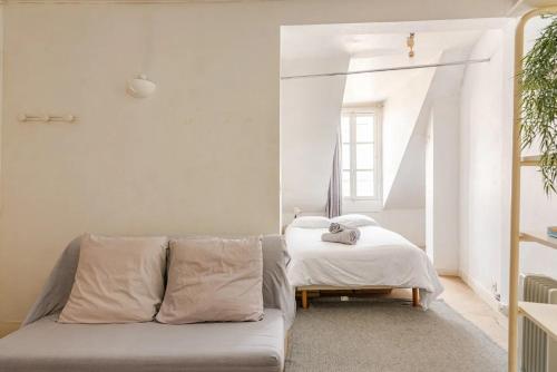 un salon avec un canapé et un lit dans l'établissement Appartement 4 personnes au centre Paris - Chatelet, à Paris