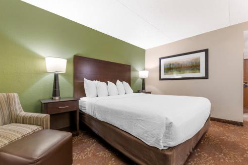a hotel room with a large bed and a chair at Best Western Plus New Ulm in New Ulm