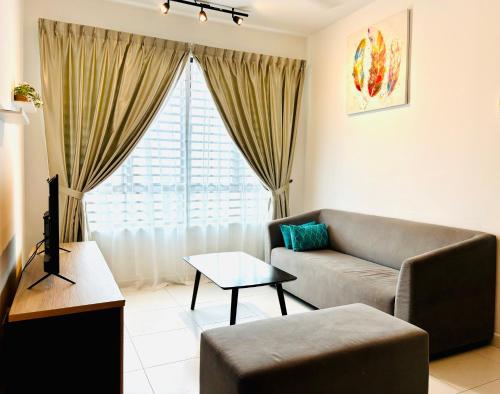 a living room with a couch and a large window at Nureenas Residence Condominium in Ayer Keroh