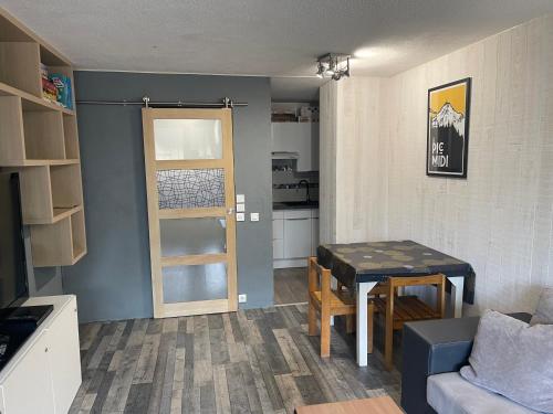 Il comprend un petit salon avec une table et une cuisine. dans l'établissement Appartement au pied des pistes, à La Mongie