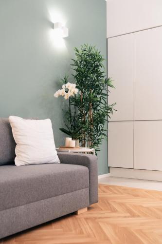 a living room with a couch and a plant at Emma Bliss Apartment in Rome