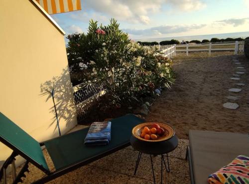 - un bol de fruits assis sur un banc à côté d'une table dans l'établissement Bel appartement face mer et accès plage, à Saint-Sébastien