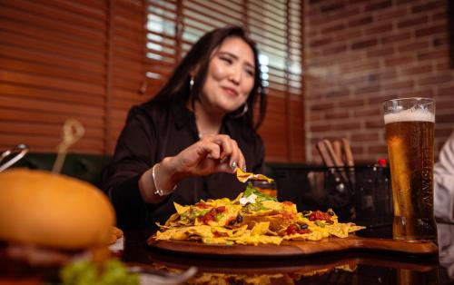 a woman sitting at a table with a plate of food at Holiday Inn Express Dubai, Jumeirah by IHG in Dubai