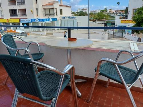 a table and chairs sitting on a balcony with a view of a city at Guest House Casa Ramos on the Strip in Albufeira