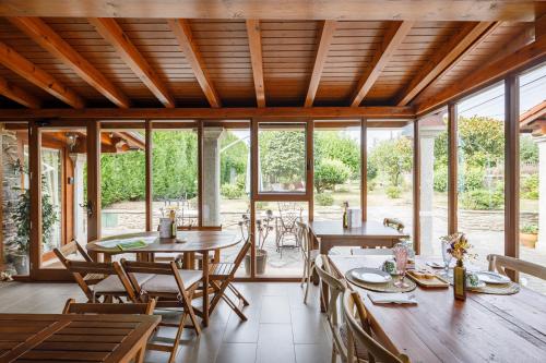 a dining room with tables and chairs and windows at Adega in Ordes