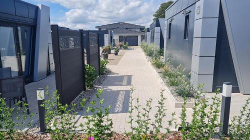 a walkway between two buildings with plants at Lins B&B Hotel Resort in Marktlustenau