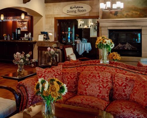 a living room with a red couch and flowers in vases at Mirbeau Inn & Spa - Skaneateles in Skaneateles