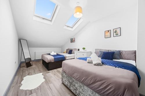 two beds in a room with white walls at Budget 2-Bed House 10mins to Leeds City Centre in Leeds