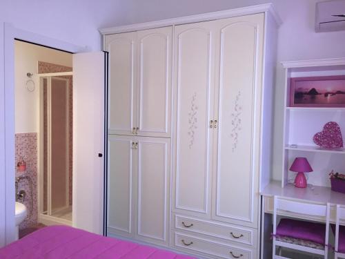 a bedroom with a large white cabinet in a room at L'Aurora Viola in Carbonia