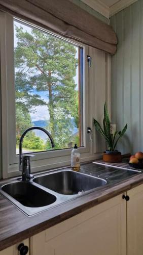 eine Küche mit Spüle und Fenster in der Unterkunft Buavollen in Vågbø