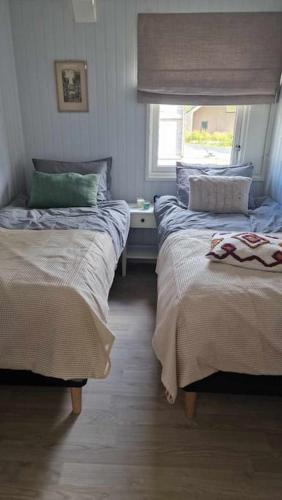 ein Schlafzimmer mit zwei Betten und einem Fenster in der Unterkunft Buavollen in Vågbø