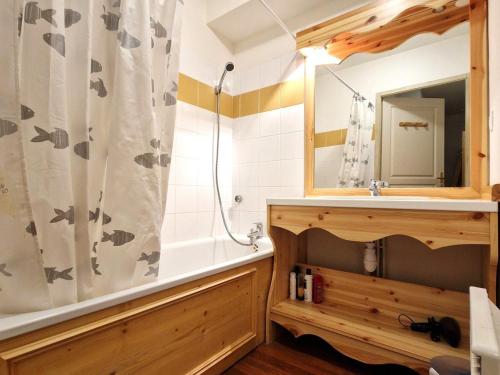 une salle de bain avec une baignoire, un lavabo et un miroir dans l'établissement Appartement 2 pièces + cabine, 6 personnes, bien situé à 30m du télécabine - Rue du Cheval Blanc, Modane - FR-1-265-187, à Valfréjus