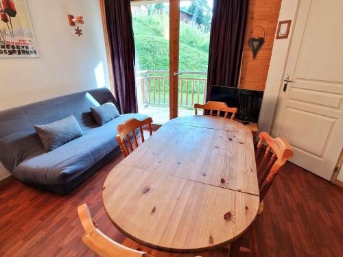 - un salon avec une table et des chaises en bois et un canapé dans l'établissement Appartement 2 pièces + cabine, 6 personnes, bien situé à 30m du télécabine - Rue du Cheval Blanc, Modane - FR-1-265-187, à Valfréjus