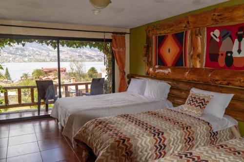 a bedroom with two beds and a balcony at Hospedaje Campo Lago y Glamping in Otavalo
