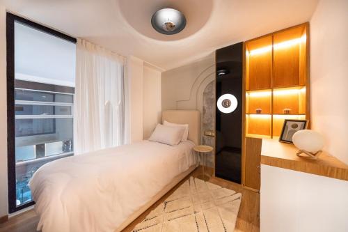 a bedroom with a bed and a large window at Ecrin Secret, Duplex Premium, Calme, Proche Corniche & Médina, Parking, WIFI - Tanger Centre in Tangier