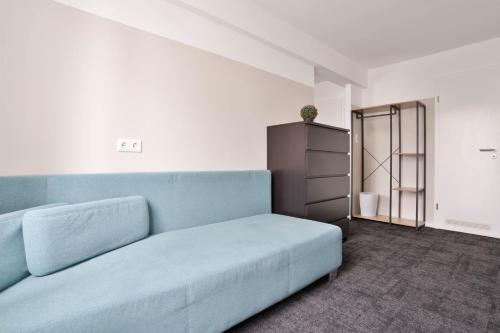 a living room with a blue couch and a cabinet at Stilvolle Apartments in Bonn I home2share in Bonn