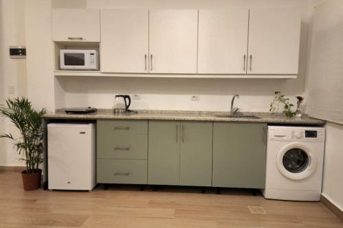 Ash ShumaysānīにあるGoga Apartment in Jabal Amman near Rainbow Streetのシンクと洗濯機付きのキッチン