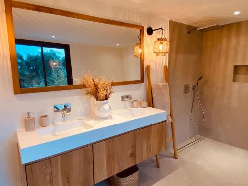 une salle de bain avec un lavabo et un miroir dans l'établissement villa la Chamade, superbe vue mer, 12 pers, piscine, à La Croix-Valmer