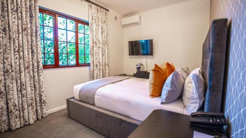 a bedroom with a large bed and a window at Palm House Boutique Hotel and Spa in Cape Town