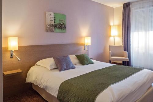 Ένα ή περισσότερα κρεβάτια σε δωμάτιο στο Brit Hotel Châteaudun