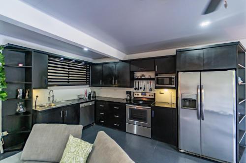 a kitchen with black cabinets and a stainless steel refrigerator at Good Life Lodge in Sámara