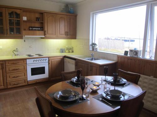 a kitchen with a wooden table with chairs and a sink at G4 Apartment in Grundarfjordur