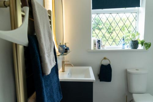 a bathroom with a sink and a window at Peacock Room at Field View Cottage in Eccleston