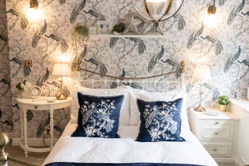 a bedroom with a bed with blue and white wallpaper at Peacock Room at Field View Cottage in Eccleston