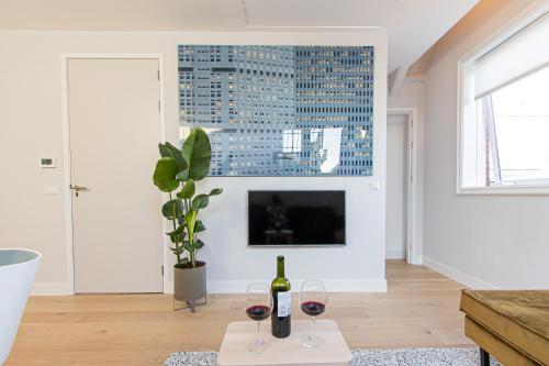 a living room with two glasses of wine on a table at OHotellMe City Apartments Rotterdam in Rotterdam