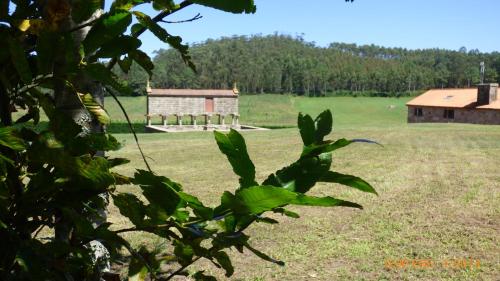 a field with a building in the middle of it at Mar do Val in Muxia